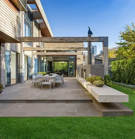 Modern outdoor patio with paver flooring, dining area, and pergola