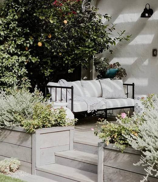 Outdoor patio seating area with garden plants and raised planters